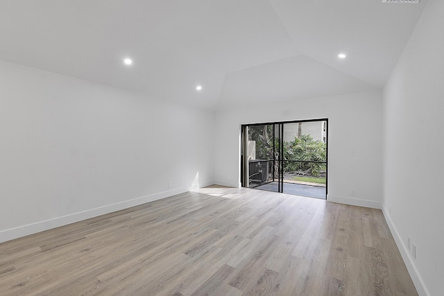 empty room with high vaulted ceiling and light hardwood / wood-style flooring