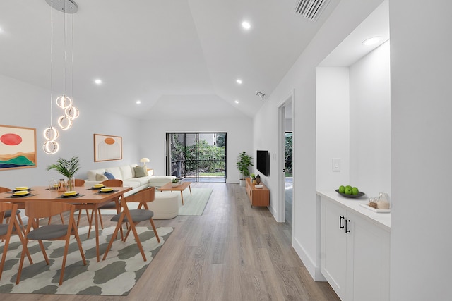 dining area featuring high vaulted ceiling and light wood-type flooring