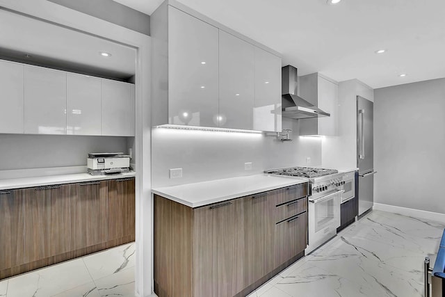 kitchen featuring high quality appliances, white cabinetry, and wall chimney range hood