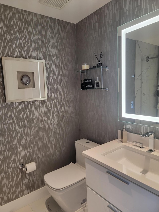 bathroom featuring tile patterned floors, vanity, toilet, and walk in shower