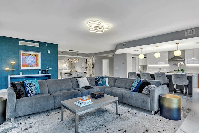 living room featuring a notable chandelier and sink