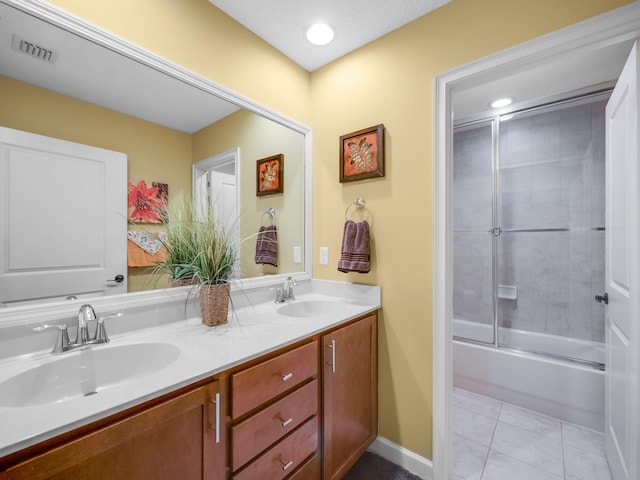 bathroom with tile patterned floors, vanity, and enclosed tub / shower combo