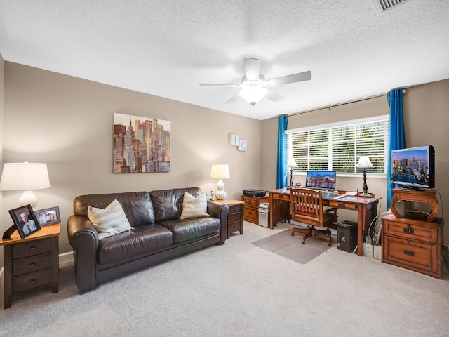 home office featuring light carpet, a textured ceiling, and ceiling fan