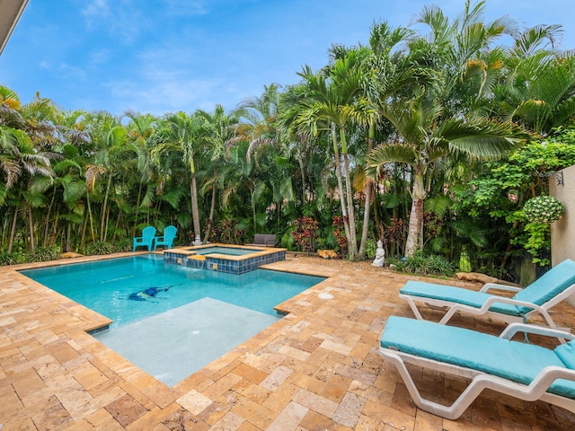 view of pool with an in ground hot tub and a patio