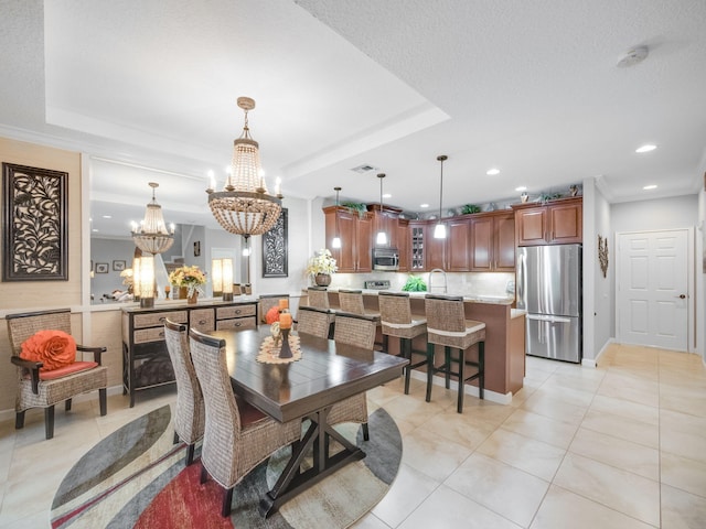 tiled dining room featuring sink, a notable chandelier, a raised ceiling, and a textured ceiling