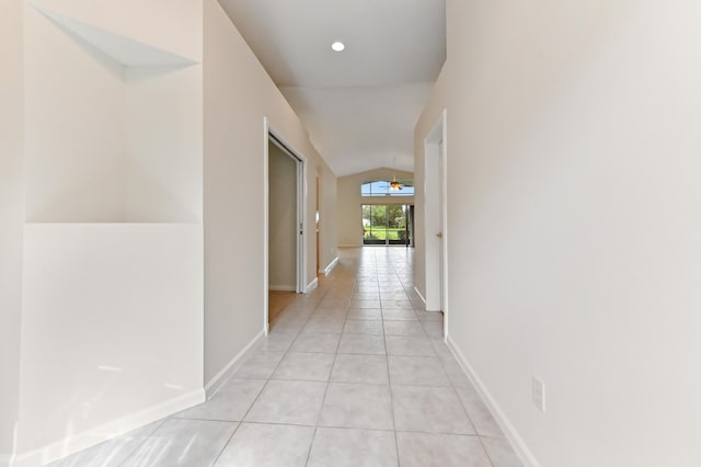 hallway with lofted ceiling and light tile patterned floors