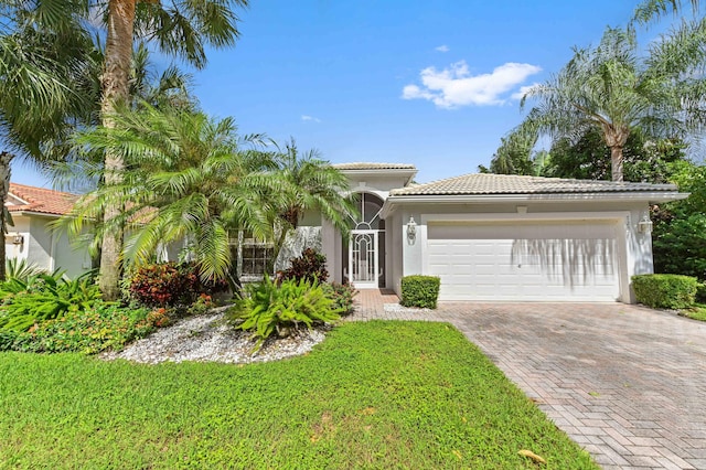 mediterranean / spanish-style house featuring a garage and a front lawn