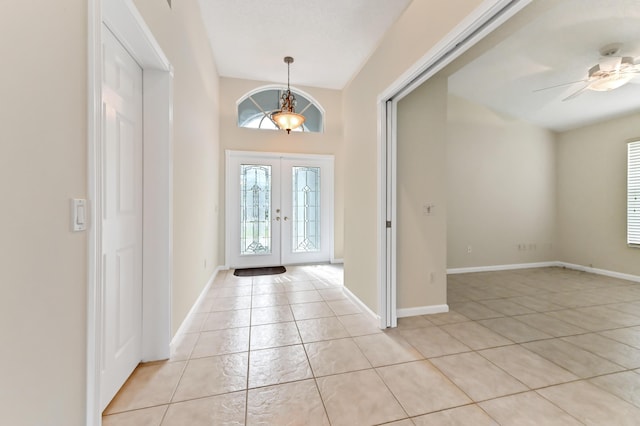 foyer featuring light tile patterned floors, french doors, and ceiling fan