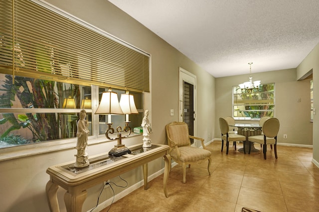 living area with light tile patterned flooring, an inviting chandelier, and a textured ceiling