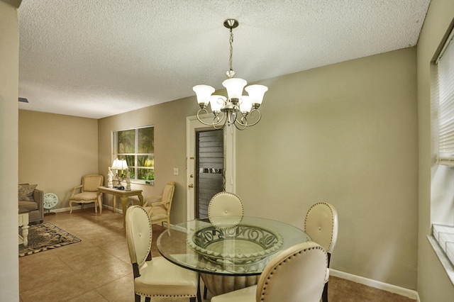 tiled dining space featuring a notable chandelier, a wealth of natural light, and a textured ceiling