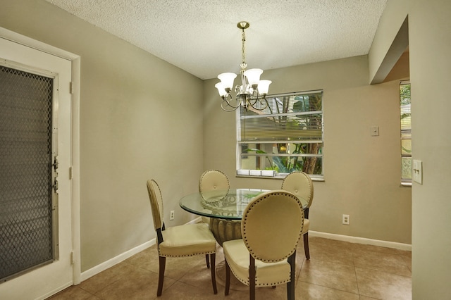 dining space featuring light tile patterned floors, plenty of natural light, and an inviting chandelier