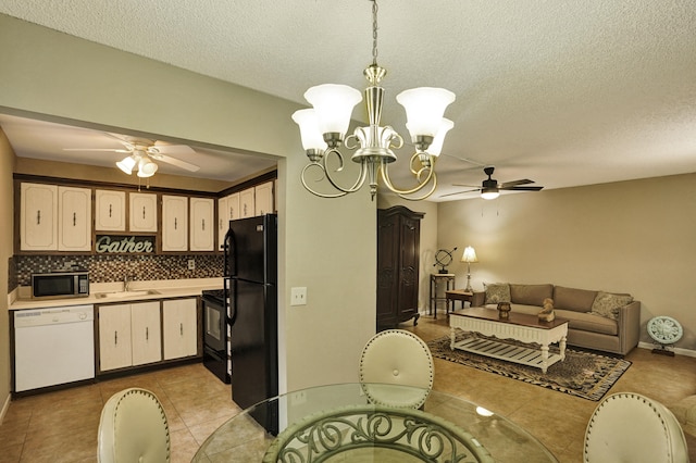 kitchen featuring light tile patterned flooring, decorative backsplash, hanging light fixtures, black appliances, and a textured ceiling