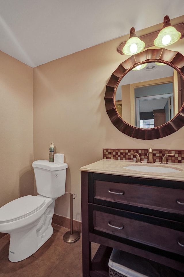 bathroom with tile patterned flooring, tasteful backsplash, vanity, and toilet