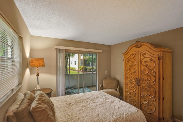 bedroom featuring a textured ceiling and access to exterior