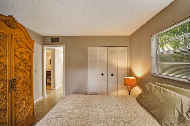 bedroom with a textured ceiling and a closet