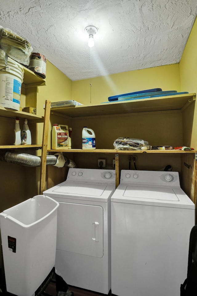 laundry area with washer and clothes dryer and a textured ceiling