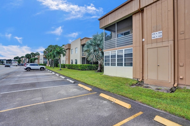 view of vehicle parking with a lawn