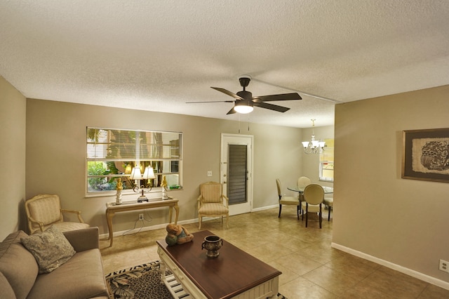 living room with ceiling fan with notable chandelier, tile patterned floors, and a textured ceiling