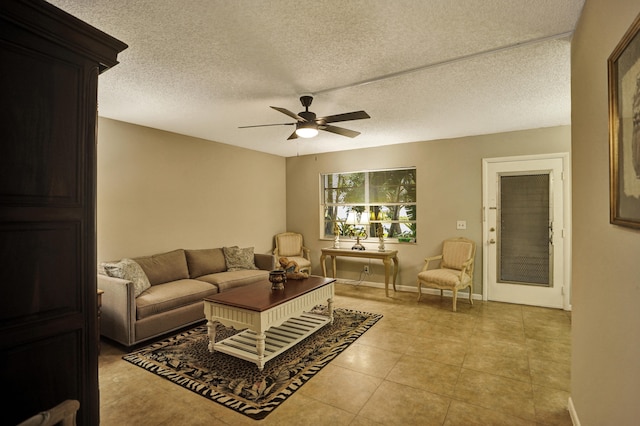 living room featuring ceiling fan, a textured ceiling, and light tile patterned floors