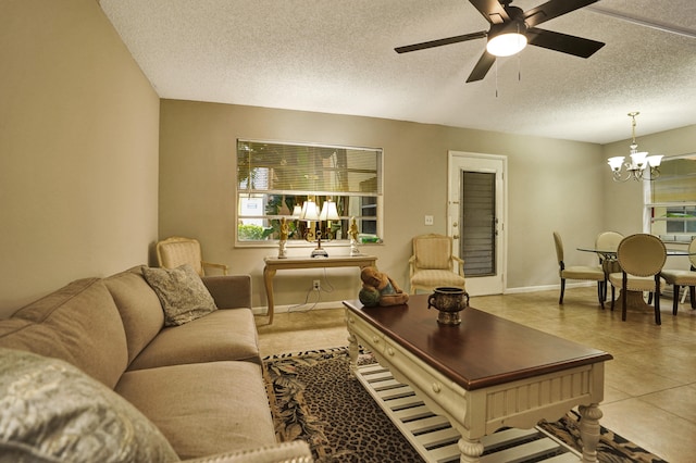 tiled living room with a textured ceiling and ceiling fan with notable chandelier