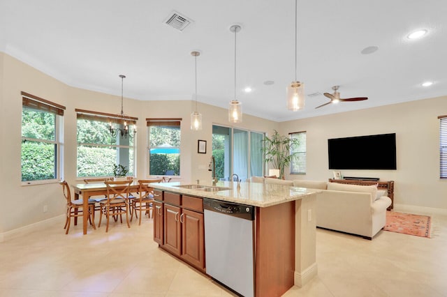 kitchen with light stone counters, a kitchen island with sink, stainless steel dishwasher, pendant lighting, and sink