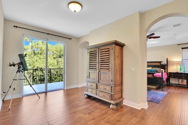 interior space with hardwood / wood-style floors, access to exterior, and ceiling fan