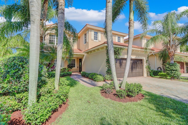 mediterranean / spanish-style home with a front yard and a garage