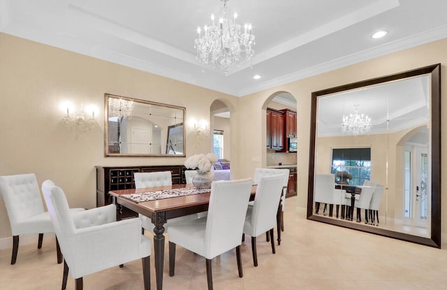 tiled dining room with a healthy amount of sunlight, crown molding, and a raised ceiling