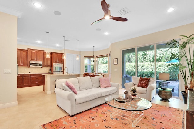 living room featuring ornamental molding, light tile patterned floors, and ceiling fan with notable chandelier