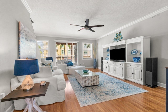 living room featuring ornamental molding, a textured ceiling, ceiling fan, and light hardwood / wood-style floors