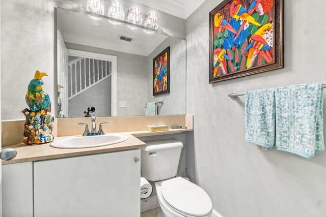 bathroom with crown molding, vanity, and toilet