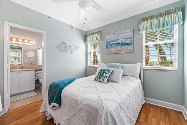 bedroom with hardwood / wood-style flooring, ensuite bathroom, ornamental molding, ceiling fan, and sink