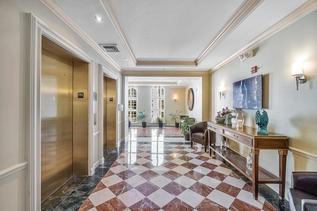 hallway with ornamental molding, a tray ceiling, and elevator