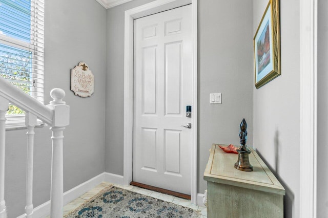 tiled foyer featuring ornamental molding