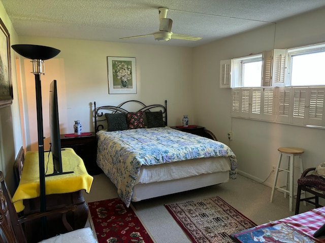 carpeted bedroom featuring a textured ceiling and ceiling fan