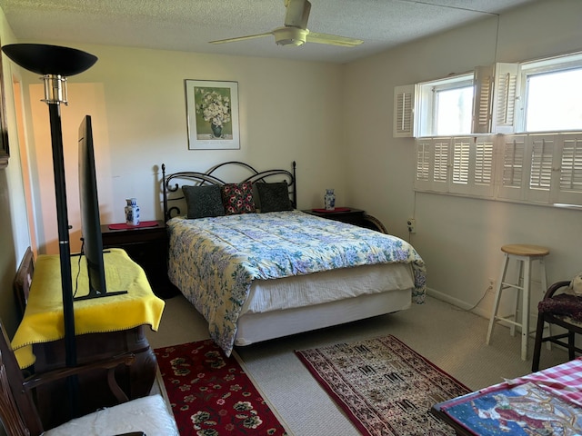 bedroom featuring carpet floors, a textured ceiling, and ceiling fan