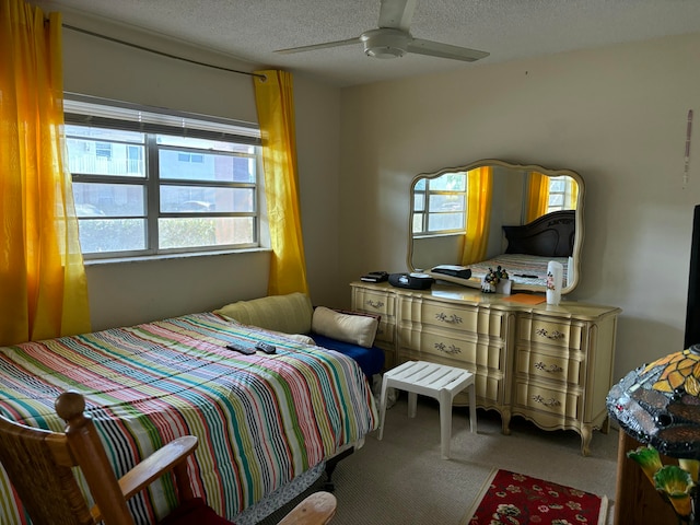 carpeted bedroom with a textured ceiling and ceiling fan