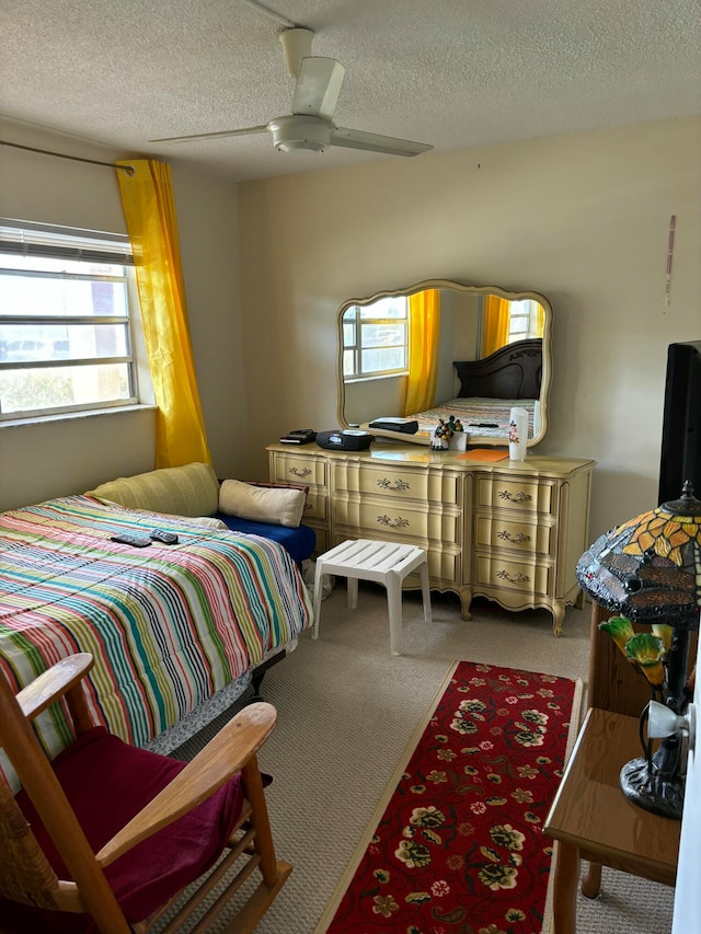 bedroom with a textured ceiling, carpet, and ceiling fan