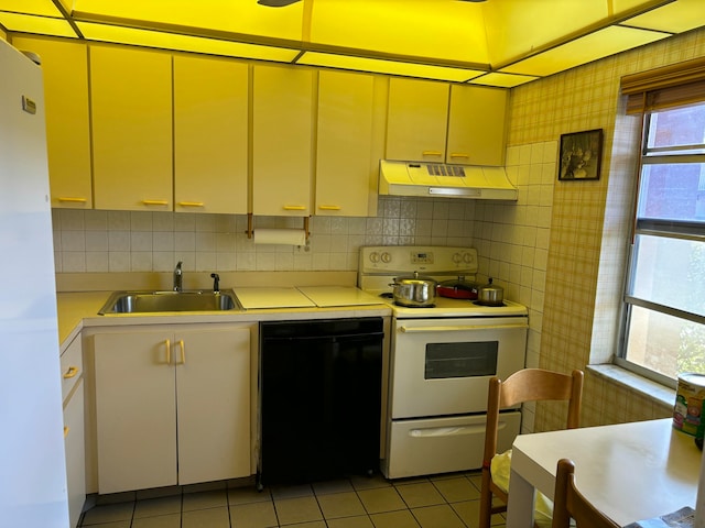 kitchen featuring a wealth of natural light, sink, light tile patterned flooring, and white appliances