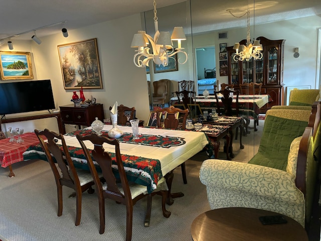 dining space with a chandelier and rail lighting