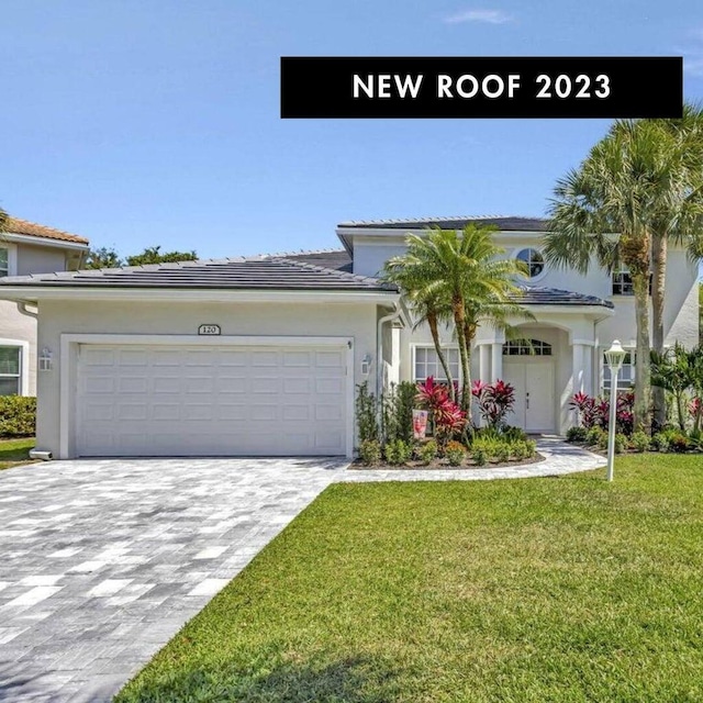 view of front of house with a garage and a front lawn