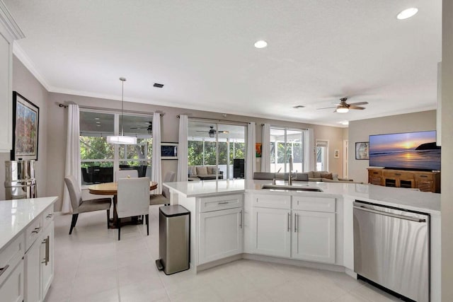 kitchen featuring ceiling fan, sink, hanging light fixtures, stainless steel dishwasher, and white cabinetry