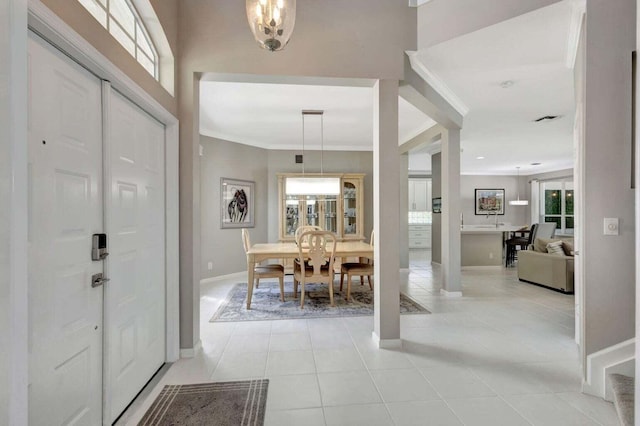 foyer featuring light tile patterned flooring, crown molding, and a chandelier