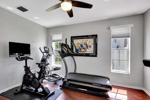 workout area with ceiling fan and dark wood-type flooring