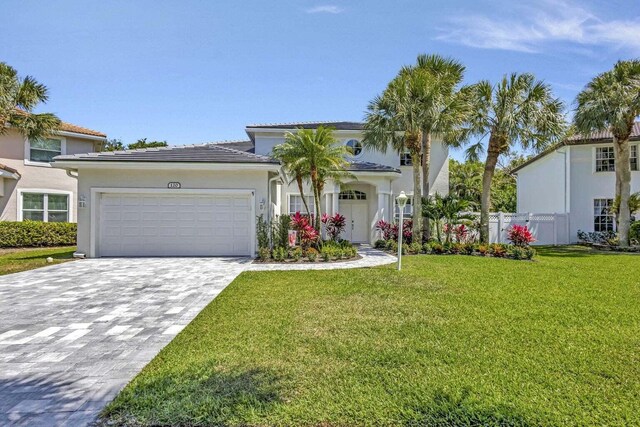 120 Jones Creek Dr, Jupiter, FL 33458 - view of front of property featuring decorative driveway, fence, a front lawn, an attached garage, and stucco siding
