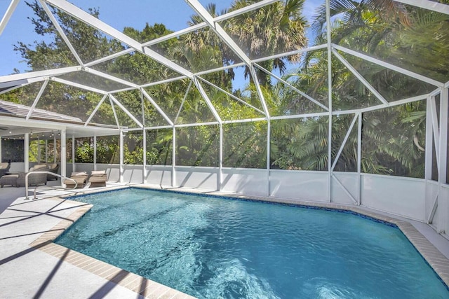 view of pool with a patio and glass enclosure