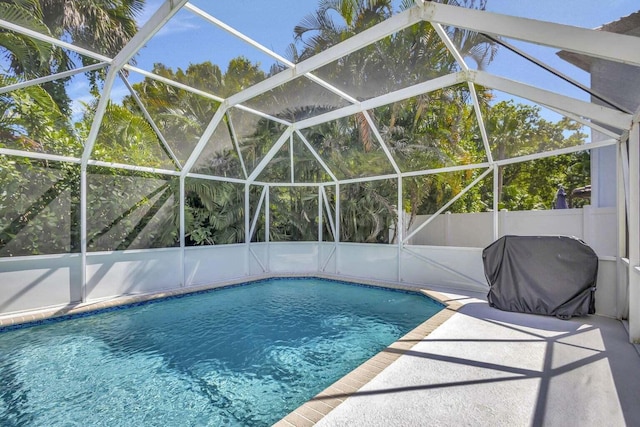 view of pool featuring grilling area, glass enclosure, and a patio