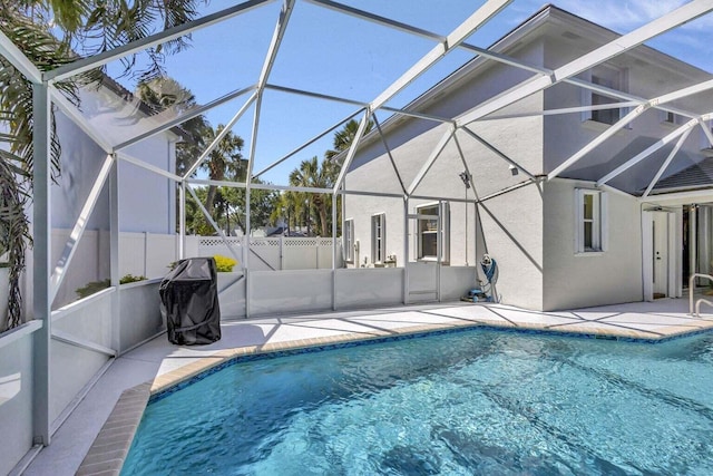 view of swimming pool featuring a lanai and a patio