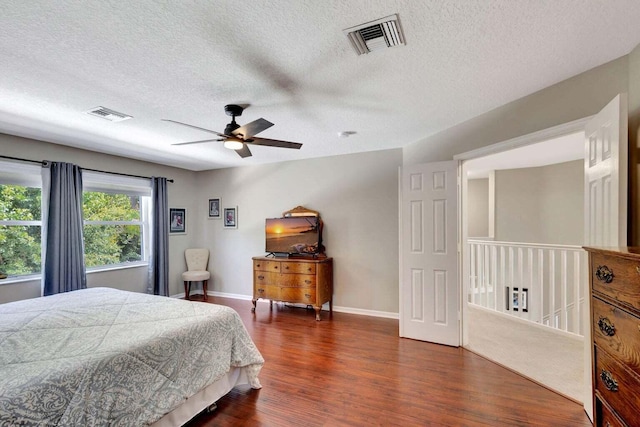 bedroom with dark hardwood / wood-style flooring, a textured ceiling, and ceiling fan