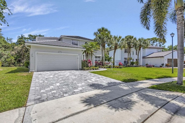 120 Jones Creek Dr, Jupiter, FL 33458 - traditional-style house featuring a front lawn, decorative driveway, stucco siding, an attached garage, and a tile roof